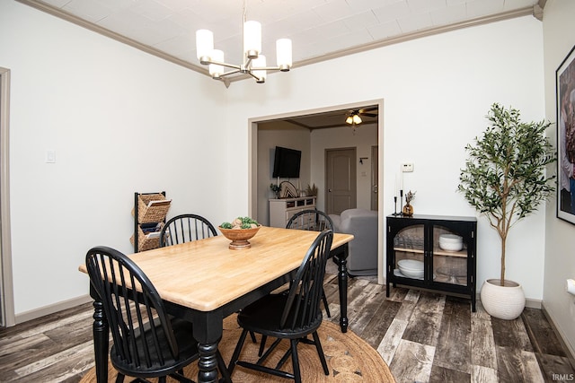 dining room with baseboards, ceiling fan with notable chandelier, dark wood finished floors, and ornamental molding