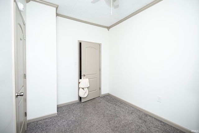 empty room with crown molding, carpet flooring, and baseboards