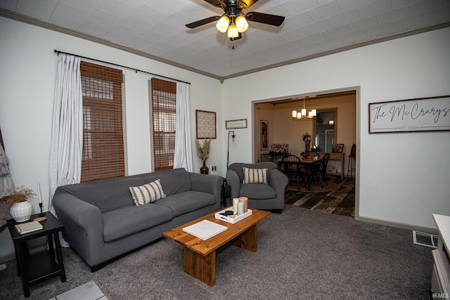 carpeted living room featuring visible vents, ceiling fan with notable chandelier, baseboards, and ornamental molding