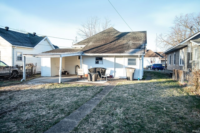 rear view of property featuring a patio, a lawn, fence, and a shingled roof