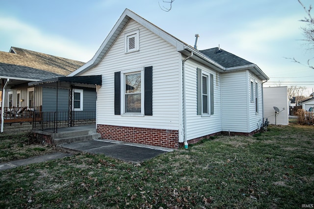 view of home's exterior featuring a lawn and roof with shingles