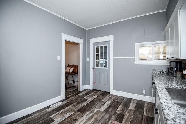 dining area featuring baseboards, dark wood-style floors, and crown molding