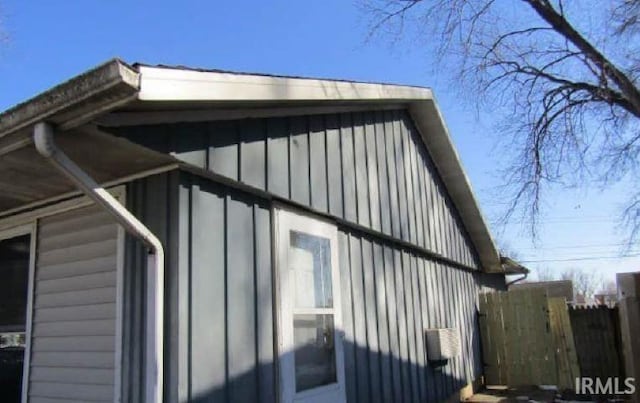 view of home's exterior featuring board and batten siding and fence