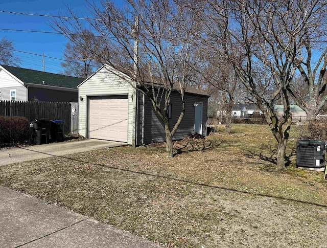 garage featuring central AC, driveway, and fence