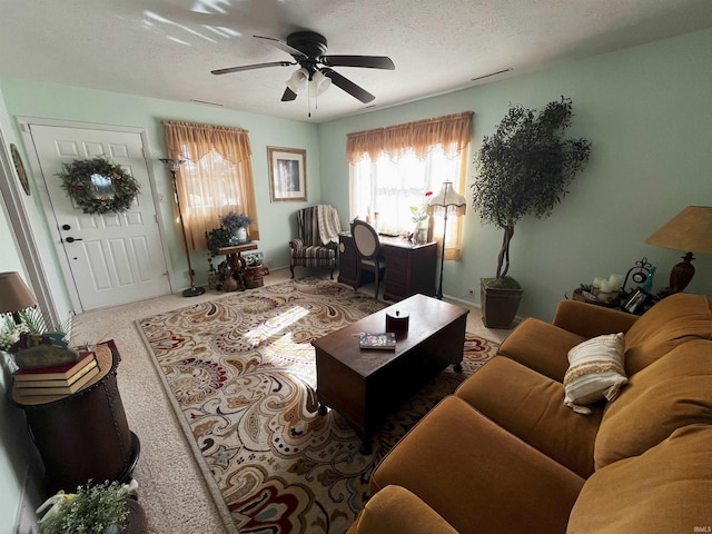 living area with visible vents, carpet, ceiling fan, and a textured ceiling