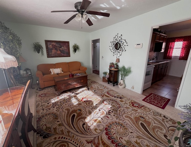 carpeted living room with ceiling fan