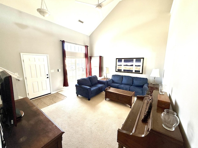 living area featuring carpet, visible vents, and high vaulted ceiling