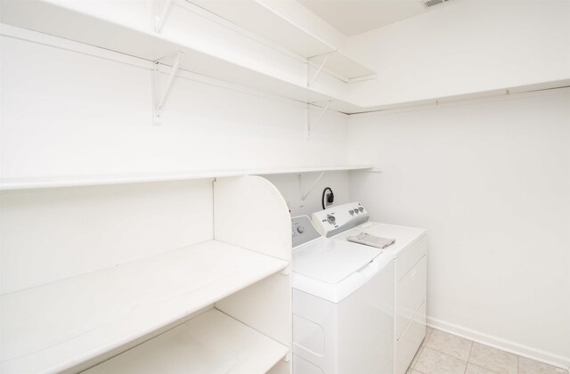 washroom with visible vents, independent washer and dryer, light tile patterned flooring, baseboards, and laundry area