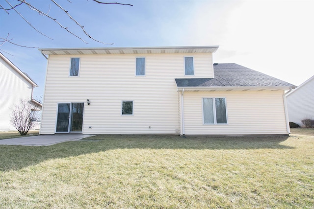 back of property featuring a patio area, a lawn, and a shingled roof