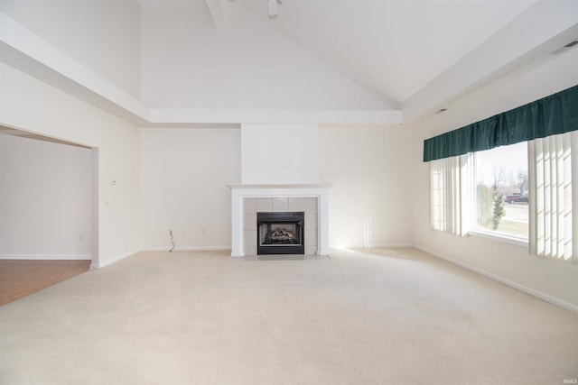 unfurnished living room featuring visible vents, high vaulted ceiling, carpet floors, baseboards, and a tile fireplace