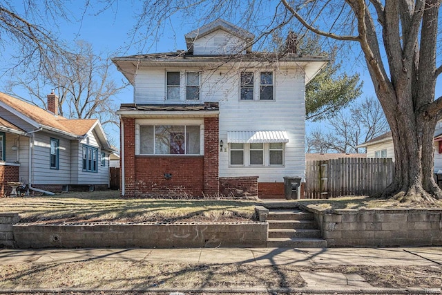 traditional style home with brick siding and fence