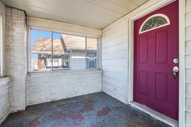 entrance to property featuring brick siding and a porch