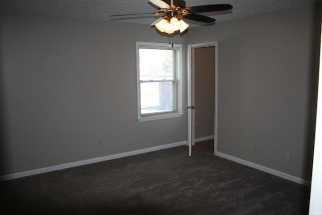 unfurnished room featuring ceiling fan, a textured ceiling, baseboards, and dark colored carpet