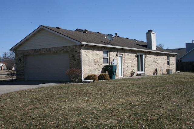 view of side of home featuring driveway, an attached garage, a yard, central AC, and a chimney