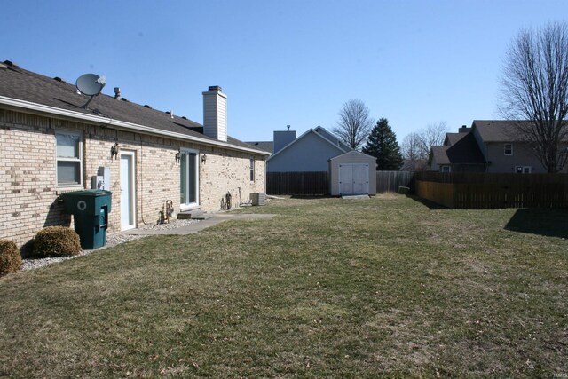 view of yard featuring an outbuilding, central air condition unit, fence private yard, and a storage shed