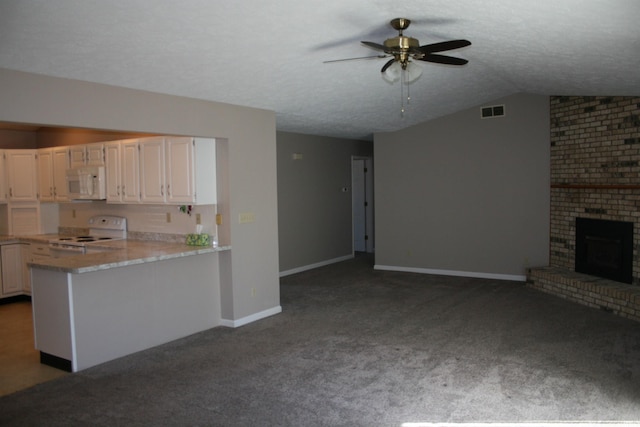 kitchen with visible vents, open floor plan, vaulted ceiling, a fireplace, and white appliances