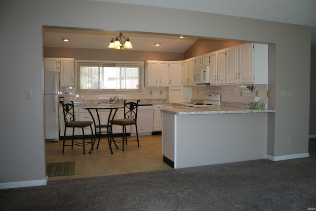 kitchen featuring backsplash, white cabinets, white appliances, and a peninsula