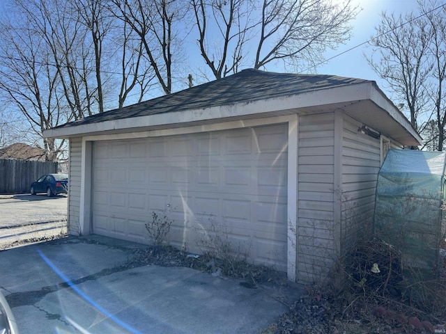 detached garage featuring fence