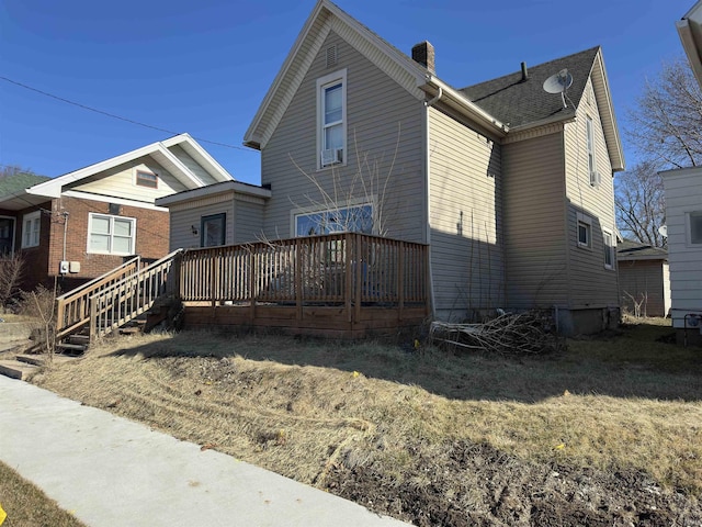 rear view of house featuring a deck and a chimney