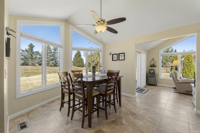 dining area featuring a wealth of natural light, visible vents, light tile patterned floors, and vaulted ceiling