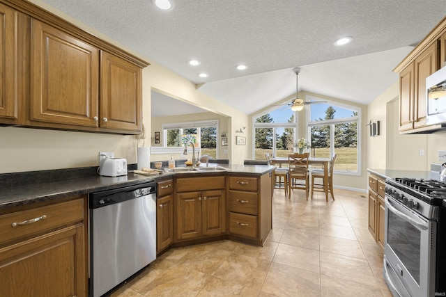 kitchen featuring a sink, dark countertops, brown cabinetry, and stainless steel appliances