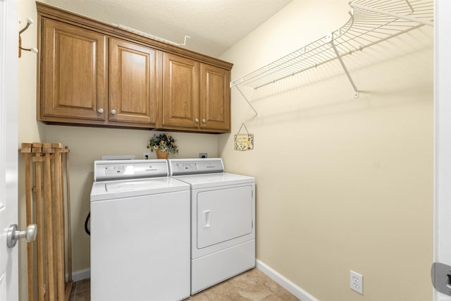 washroom featuring washer and dryer, baseboards, and cabinet space