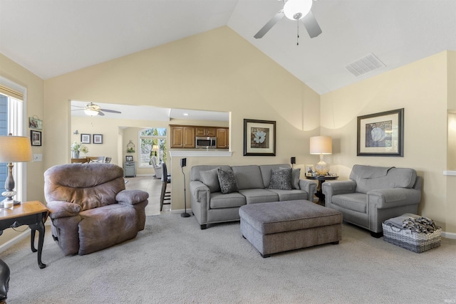 living room with visible vents, baseboards, ceiling fan, light carpet, and high vaulted ceiling