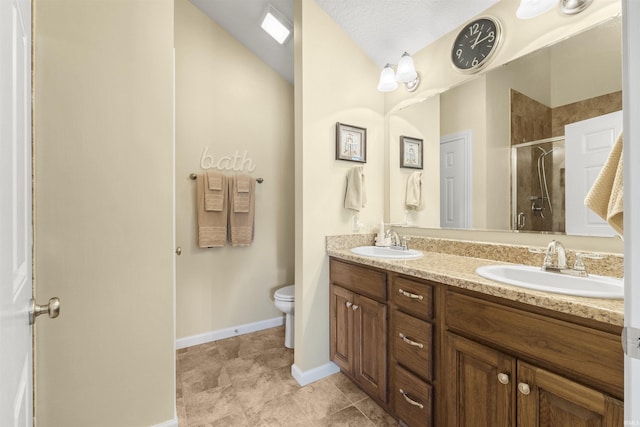 bathroom featuring double vanity, a shower stall, toilet, and a sink