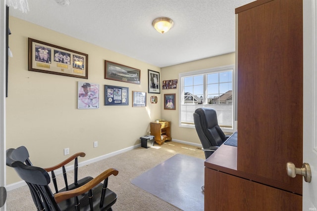 carpeted office featuring a textured ceiling and baseboards