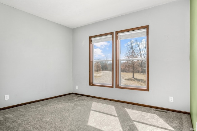 unfurnished room with baseboards, carpet floors, and visible vents