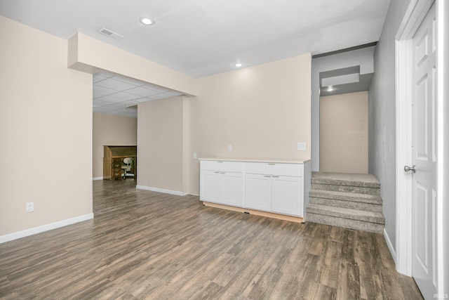 interior space with wood finished floors, visible vents, baseboards, recessed lighting, and stairs