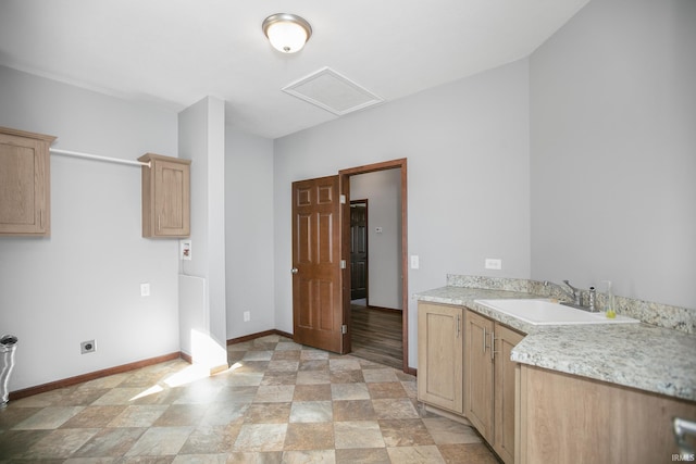 interior space with baseboards, hookup for an electric dryer, attic access, cabinet space, and a sink