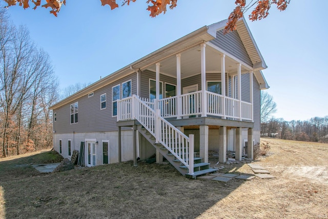 back of house featuring stairway and covered porch