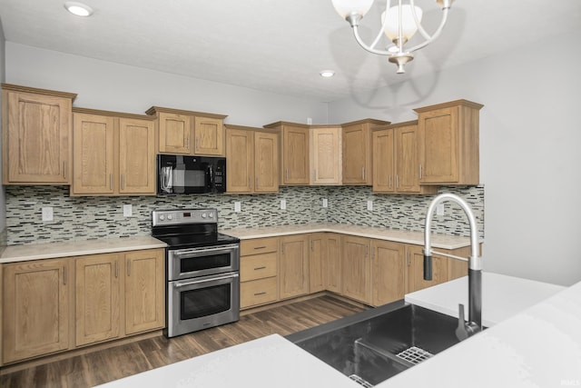 kitchen with black microwave, dark wood finished floors, light countertops, range with two ovens, and decorative backsplash