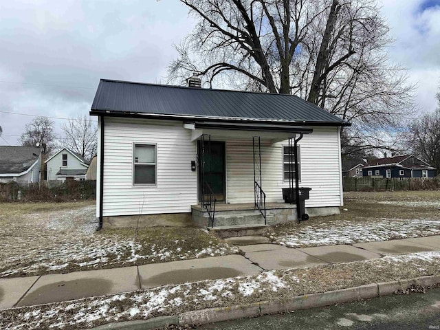 bungalow featuring covered porch and metal roof