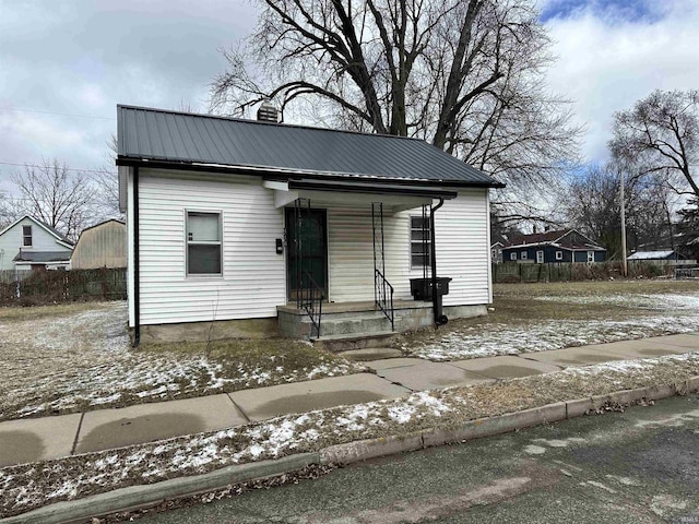 bungalow-style home featuring covered porch and metal roof