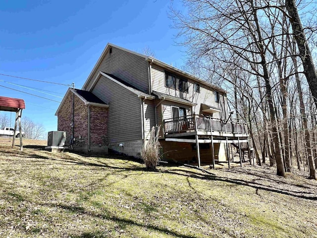 view of side of property featuring brick siding, central AC unit, and a wooden deck