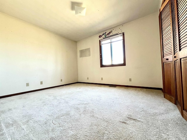 carpeted spare room with baseboards and visible vents