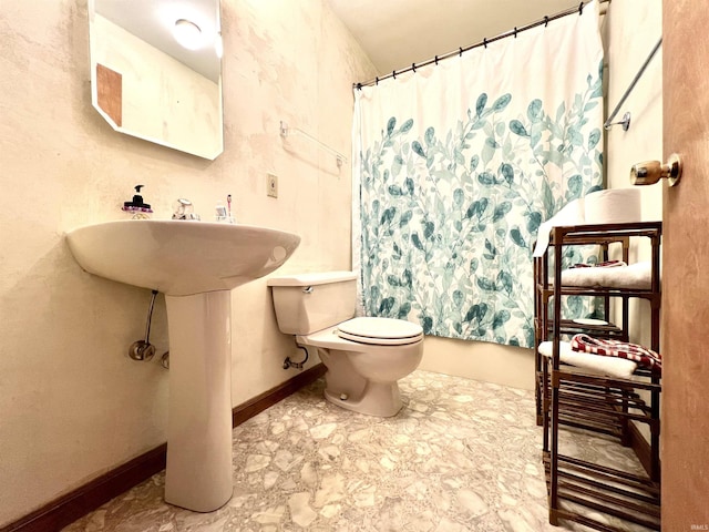 bathroom with a shower with shower curtain, baseboards, and toilet