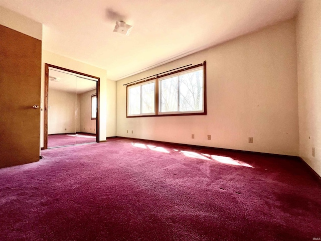 spare room with baseboards and carpet flooring