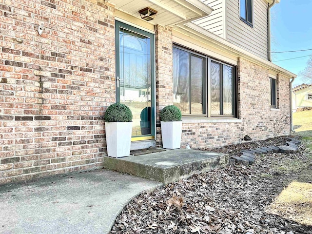 view of exterior entry featuring brick siding