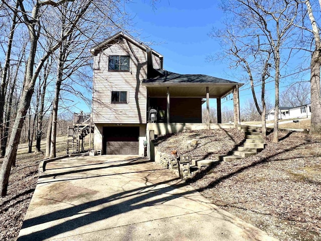 view of front of house with stairs, a garage, and driveway