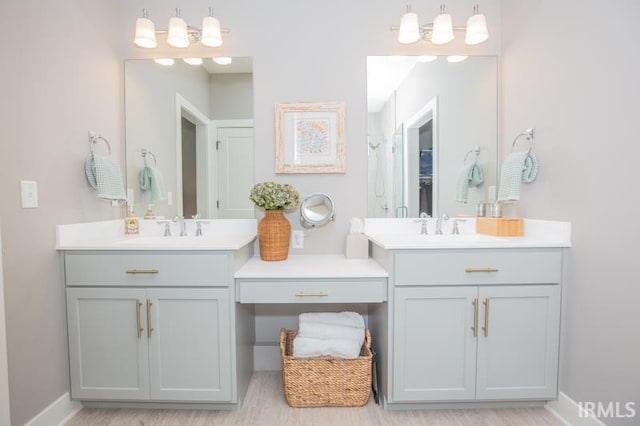 full bathroom with two vanities, wood finished floors, and a sink