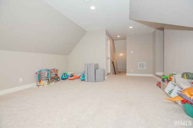 playroom featuring visible vents, light colored carpet, baseboards, and lofted ceiling