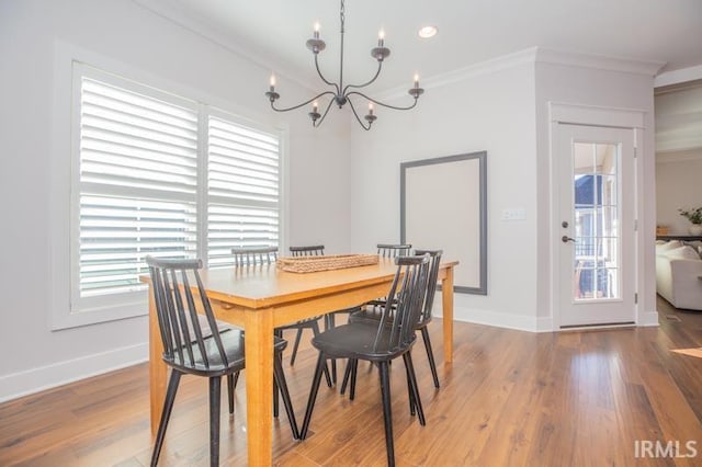 dining area with crown molding, baseboards, and light wood-type flooring