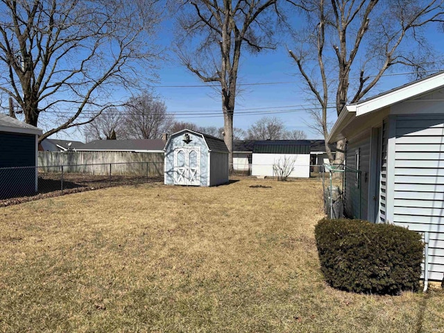 view of yard featuring a storage shed, fence, and an outbuilding