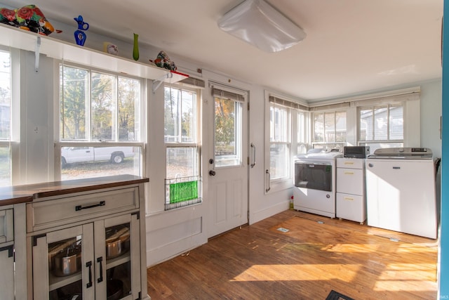 kitchen featuring washing machine and clothes dryer, baseboards, and wood finished floors