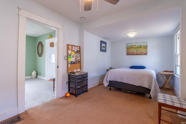 carpeted bedroom with visible vents, baseboards, and ceiling fan