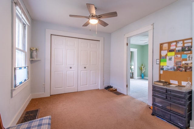 carpeted bedroom with a ceiling fan, baseboards, visible vents, and a closet