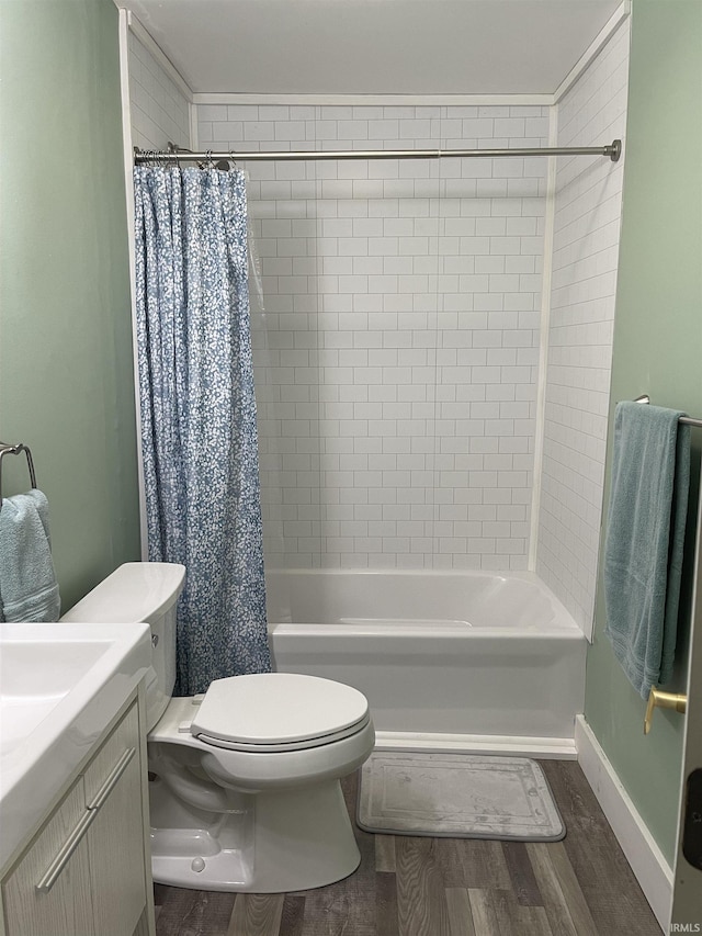 bathroom with vanity, toilet, wood finished floors, and shower / bath combo